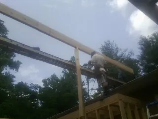 Carpenter setting a ridge beam over a new addition frame — Ice Dam Removal by Roofing Brothers in Santa Cruz