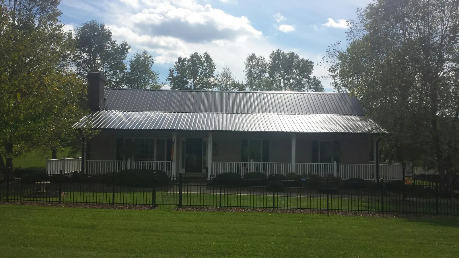 Gray metal roof on a brick ranch with a full width front porch — Gutter Guard Installation work by our crew in Santa Cruz