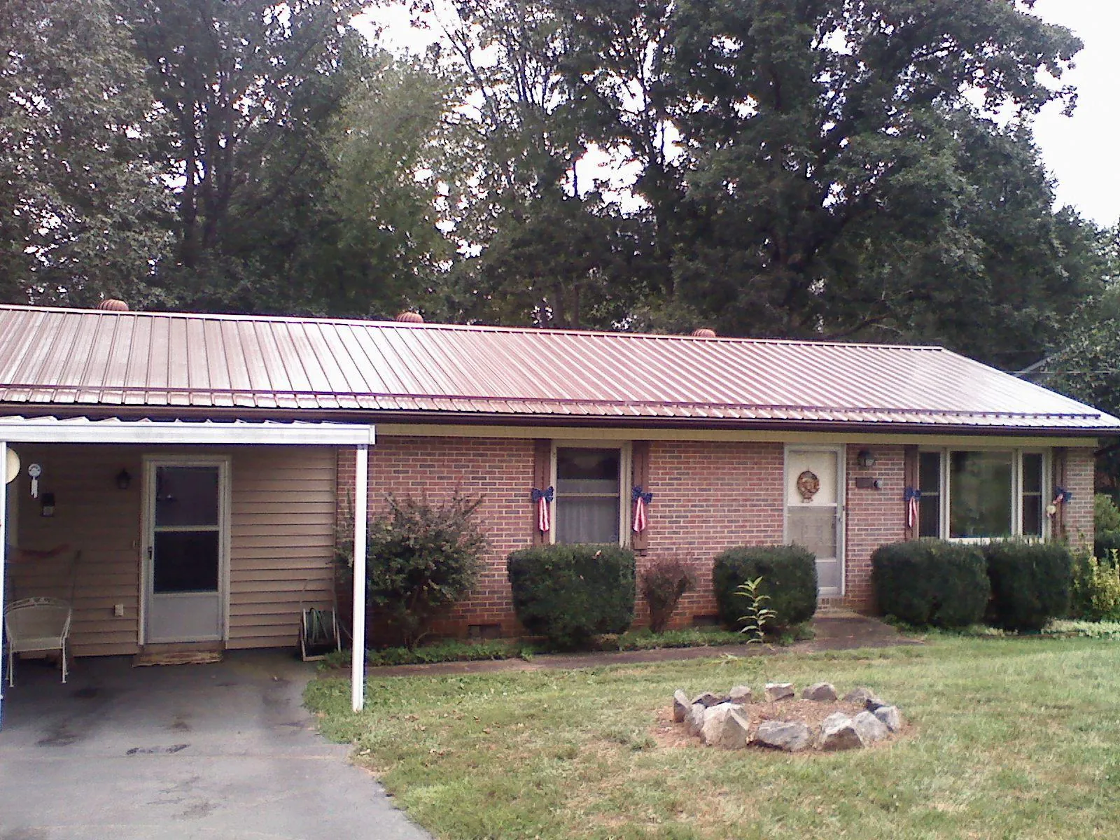 Bronze metal roof and carport on a brick ranch home — Roof Repair work by our crew in Santa Cruz